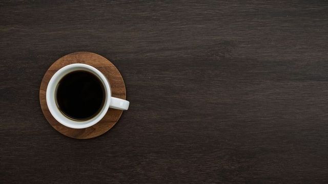 Minimalist coffee aesthetic on dark wood surface