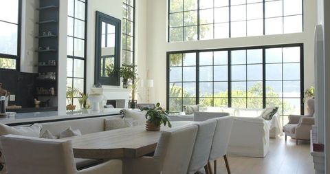 Sunlit modern farmhouse dining and living featuring large grid windows and neutral decor