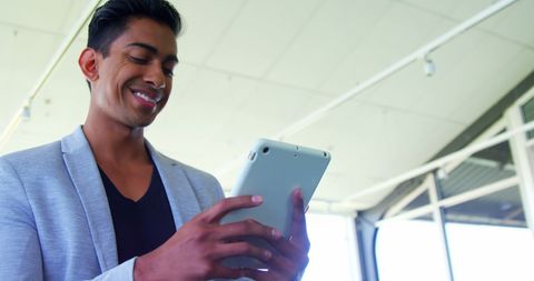 Smiling Executive Wearing Business Attire Using Digital Tablet in Office - Download Free Stock Images Pikwizard.com