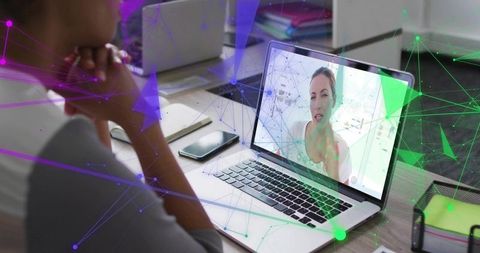 Remote Collaboration: Woman Attending Virtual Meeting at Desk with Laptop and Smartphone