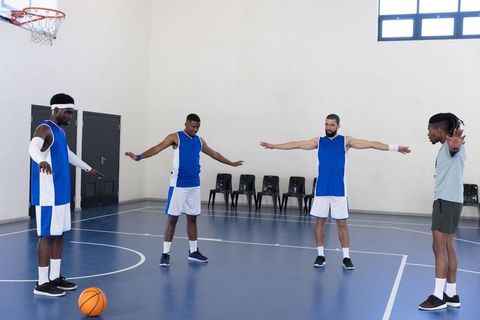 Basketball team stretching before game on indoor court
