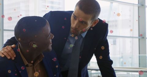 Diverse businessmen engaging in office conversation with digital elements