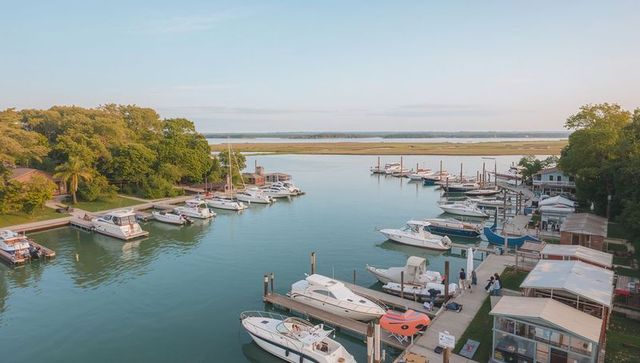 Marina channel at golden hour with leisure boats docked along tranquil coastal waterfront