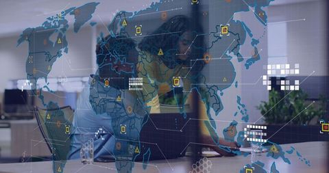 Female Analyst Leaning Over Laptop Collaborating with Holographic World Map in Open Office