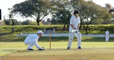 Cricket players sporting spirit on sunlit field