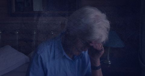 Senior woman reflecting calmly in dimly lit room