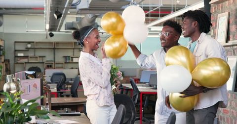 Colleagues Celebrating Achievement with Balloons in Modern Office