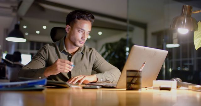 Focused Businessman Working Late in Modern Office with Laptop - Download Free Stock Images Pikwizard.com