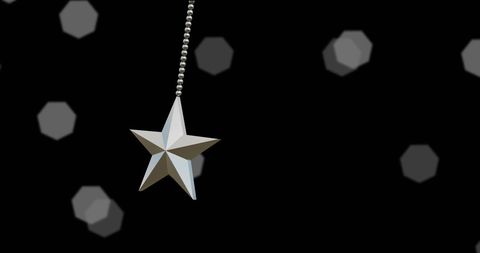 Silver star ornament hanging against dazzling night