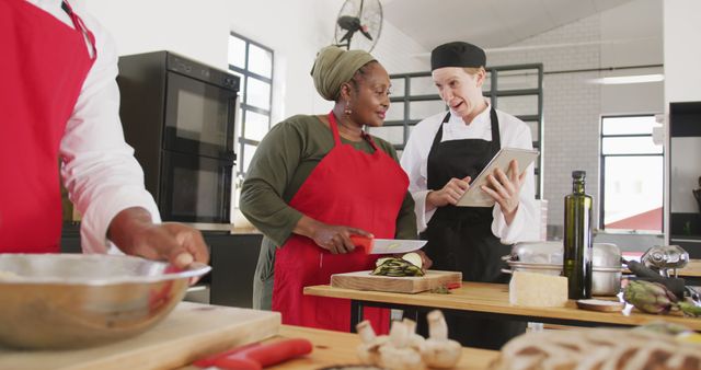 Chefs Discussing Recipe Using Tablet in Modern Kitchen - Download Free Stock Images Pikwizard.com