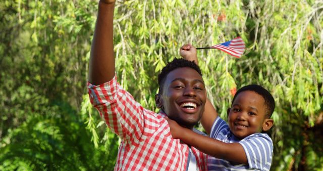 Happy African American Father and Son Celebrating Outdoors with Flag - Download Free Stock Images Pikwizard.com