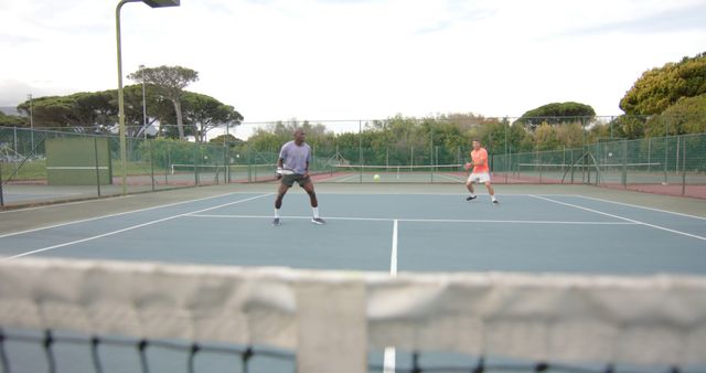 Two Men Playing Doubles Tennis Match on Outdoor Court - Download Free Stock Images Pikwizard.com