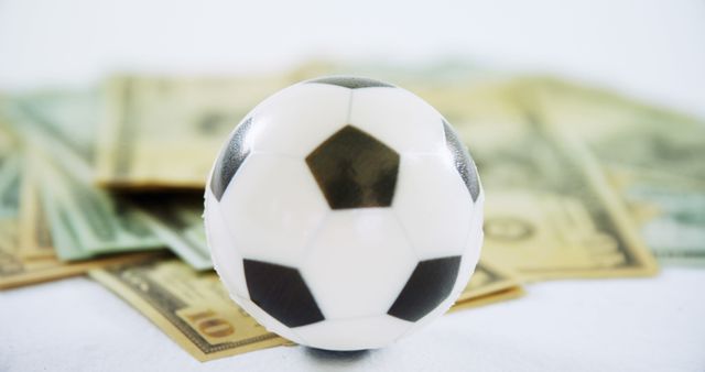 Soccer Ball with Stack of Money, Symbolizing Sports Betting or Financial Investment - Download Free Stock Images Pikwizard.com