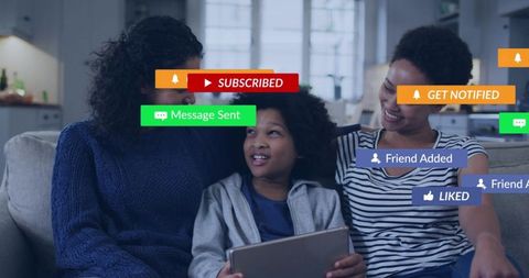 Family sharing tablet while colorful social notifications pop up, smiling and bonding in cozy living