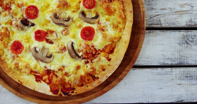 Perfect for illustrating restaurant menus, food blogs, and culinary websites. The image highlights a freshly baked cheese pizza topped with mushrooms and pepperoni, placed on a wooden surface. Great for showcasing a homely, rustic dining experience, or promoting pizza recipes and family meals.