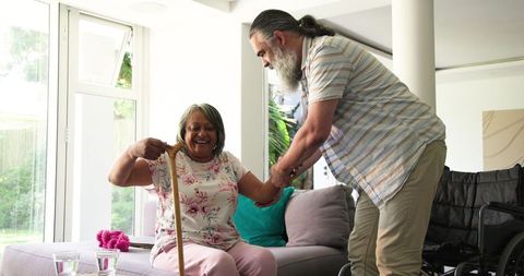 Senior Couple Enjoying Leisure Time at Home Holding Walking Stick