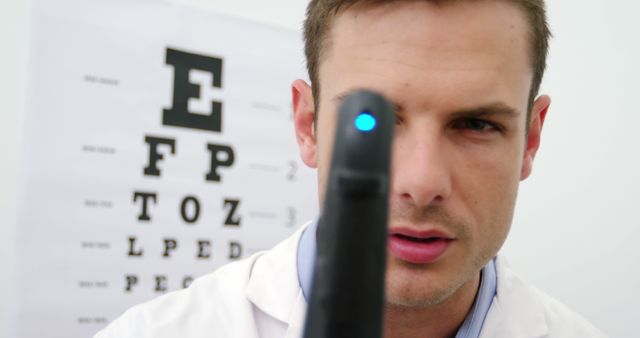 Optometrist Performing Eye Examination with Vision Chart in Background - Download Free Stock Images Pikwizard.com