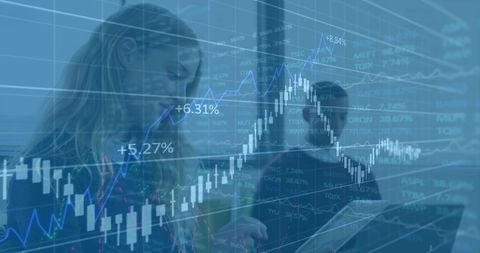 Businesswoman using digital tablet with overlayed stock graphs