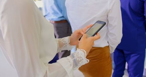 Businesswoman using smartphone in seminar queue