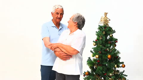 Elderly Couple Enjoying Christmas Together Near Tree