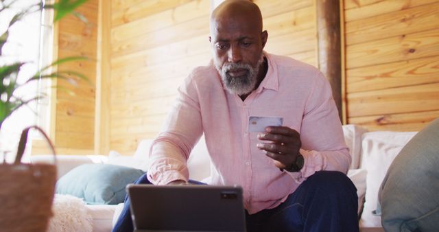 Mature man shopping online at home with tablet and credit card - Download Free Stock Images Pikwizard.com