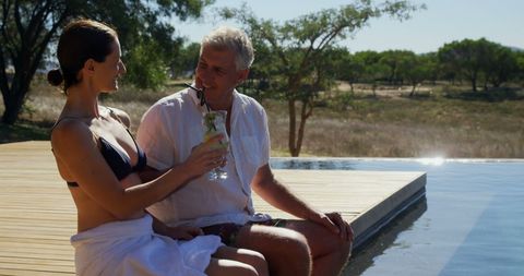 Middle-aged Caucasian Couple Savoring Poolside Relaxation