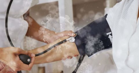 Healthcare Worker Checking Blood Pressure of Senior Amidst Virus Concept