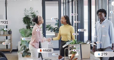 Shaking hands in open-plan office with digital engagement badges and teamwork