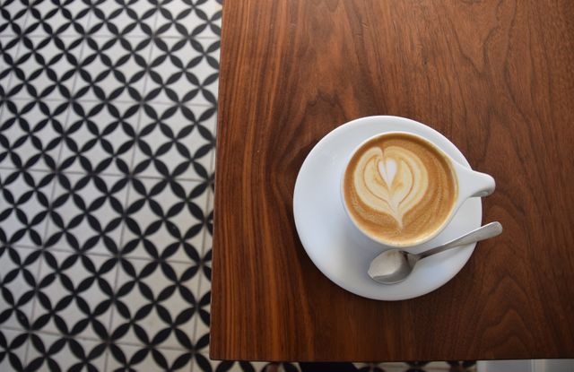 Aerial View of Latte Art on Wooden Table with Patterned Floor - Download Free Stock Photos Pikwizard.com