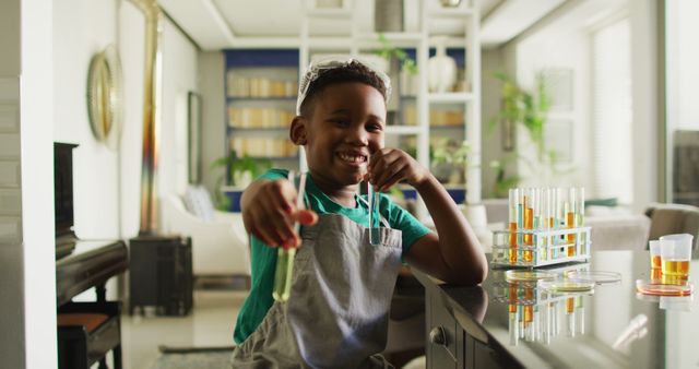 Image of happy african american boy showing sample during experimenting at home. Childhood, education, spending time at home concept.