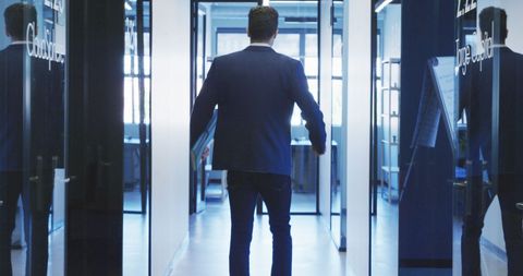 Businessman walking through modern office hallway