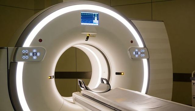 Ct scanner gantry showing illuminated led ring and patient table in modern radiology room