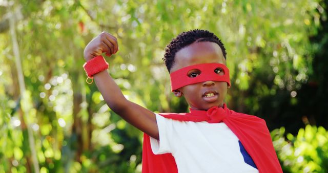 Young Boy Wearing Red Superhero Cape and Mask Flexing Arm Outdoor - Download Free Stock Images Pikwizard.com