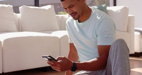 Man Relaxing at Home Browsing Smartphone in Modern Living Room