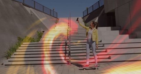 Skateboarder taking selfie on urban stairs in colorful light