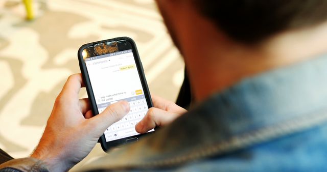 Rear view of man using mobile phone in cafe