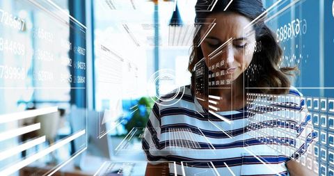 Female professional working on laptop with holographic interface and digital analytics