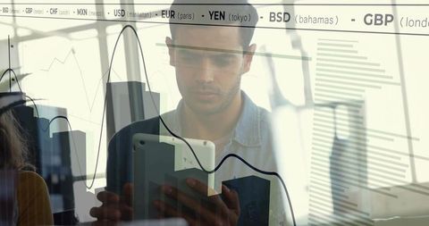 Market analyst reviewing financial data on tablet in modern office