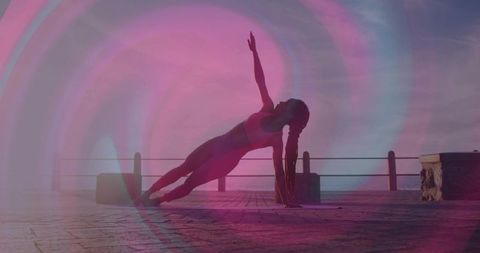 Graceful Balance of Woman in Side Plank Amidst Serene Sunrise