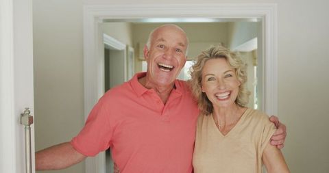 Happy Senior Couple Welcoming with a Smile at Doorway