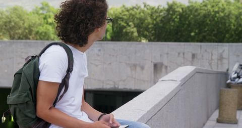 Young Man with Curly Hair Using Smartphone Salt Outdoors - Download Free Stock Images Pikwizard.com