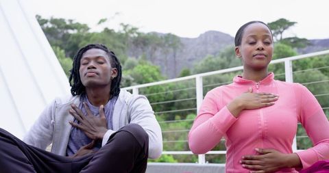 African American Couple Practicing Breathwork on Rooftop for Stress Relief and Calm