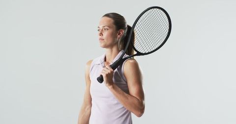 Confident Female Tennis Player Posing with Racket Embracing Determination