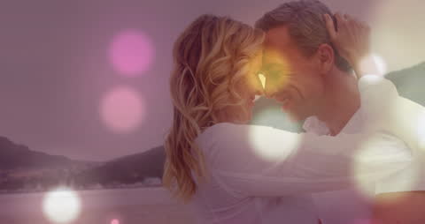 Romantic Couple Embracing on Beach with Light Effects