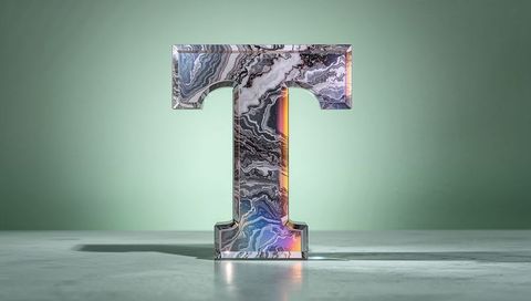 3d marble textured letter t with colorful lighting on minimal background