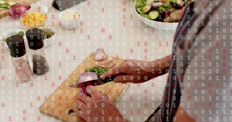 Home cook slicing red onion on wooden board preparing fresh salad with herbs and knife