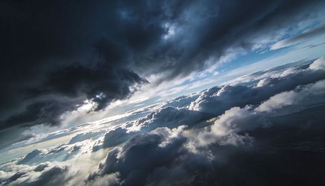 Sunlight Piercing Storm Clouds Over Horizon, Epic Aerial Cloudscape with Crepuscular Rays