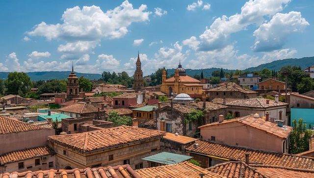 Sunlit terracotta rooftops and church towers over historic mediterranean village skyline
