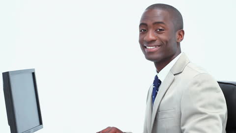 Confident Black Businessman Smiling at Office Desk in Professional Setting