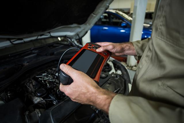 Mechanic Using Diagnostic Tool in Auto Repair Garage - Download Free Stock Photos Pikwizard.com